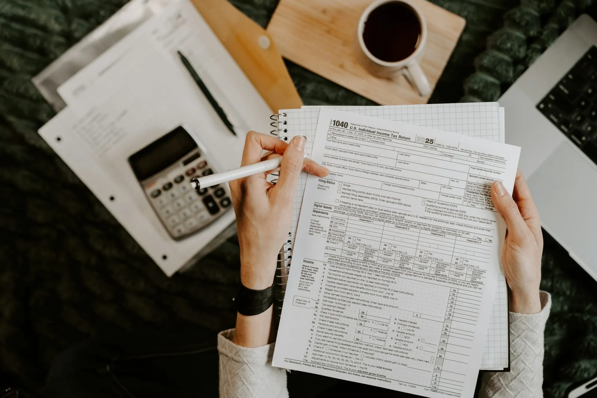 A person reviewing tax and payroll forms with a calculator